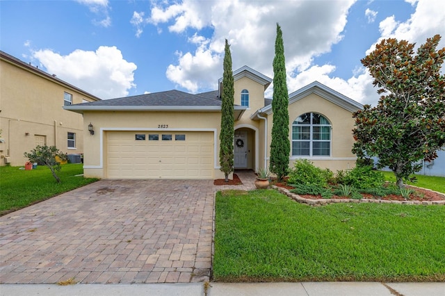 2823 Sail Breeze Way, Kissimmee, FL 34744 - single story home featuring a front yard, stucco siding, decorative driveway, and a garage
