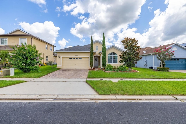 2823 Sail Breeze Way, Kissimmee, FL 34744 - view of front of home with stucco siding, driveway, a garage, and a front yard