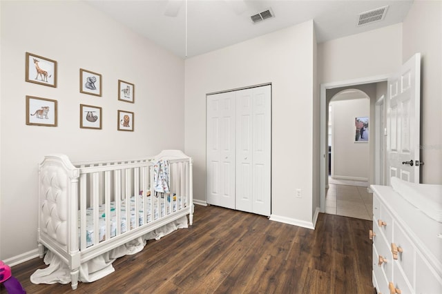 2823 Sail Breeze Way, Kissimmee, FL 34744 - bedroom with dark wood-type flooring, arched walkways, a closet, and a crib