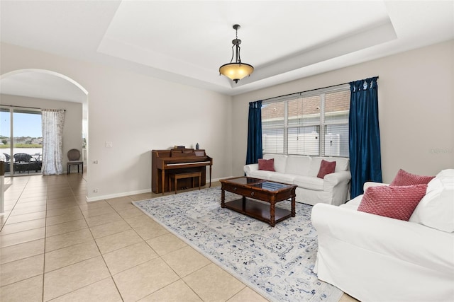 2823 Sail Breeze Way, Kissimmee, FL 34744 - living room with arched walkways, light tile patterned floors, and a tray ceiling