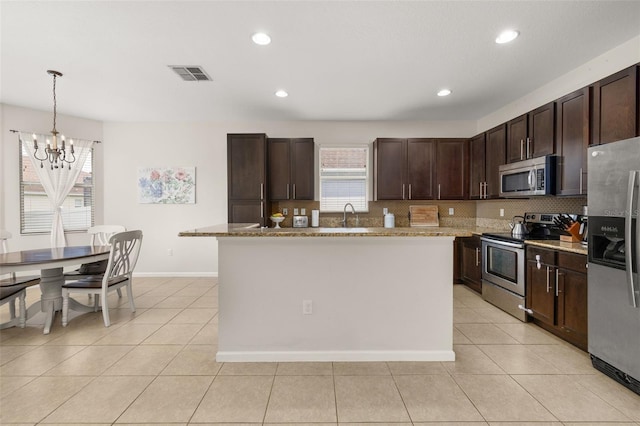 2823 Sail Breeze Way, Kissimmee, FL 34744 - kitchen with stainless steel appliances, plenty of natural light, a chandelier, decorative backsplash, and recessed lighting
