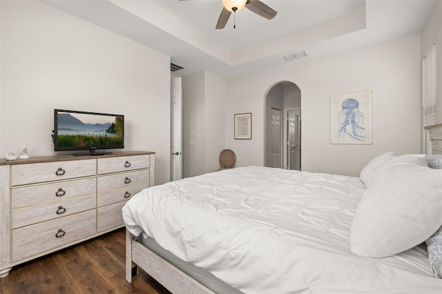 2823 Sail Breeze Way, Kissimmee, FL 34744 - bedroom with arched walkways, a raised ceiling, dark wood finished floors, and ceiling fan