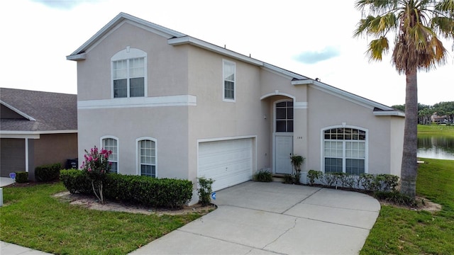 344 Bloomingdale Dr, Davenport, FL 33897 - view of front facade featuring an attached garage, concrete driveway, stucco siding, a front lawn, and a water view