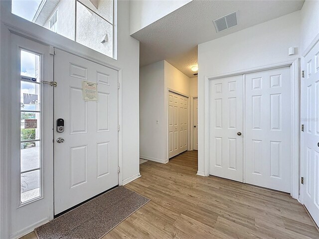 344 Bloomingdale Dr, Davenport, FL 33897 - foyer with light wood-style flooring and a high ceiling