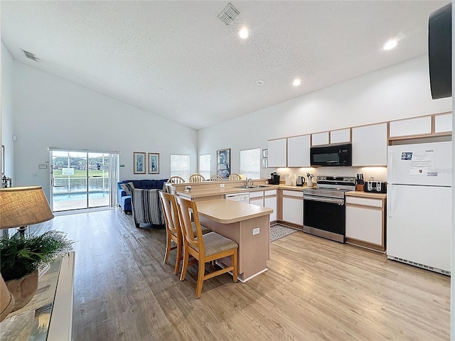 344 Bloomingdale Dr, Davenport, FL 33897 - kitchen with white appliances, a peninsula, high vaulted ceiling, light wood-type flooring, and light countertops