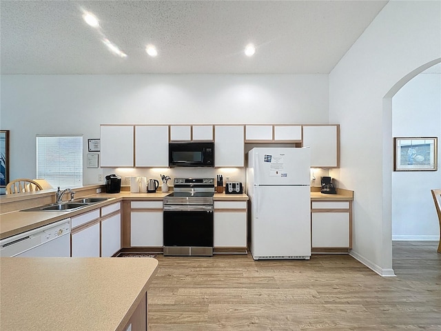 344 Bloomingdale Dr, Davenport, FL 33897 - kitchen with white appliances, white cabinets, arched walkways, light wood-type flooring, and recessed lighting