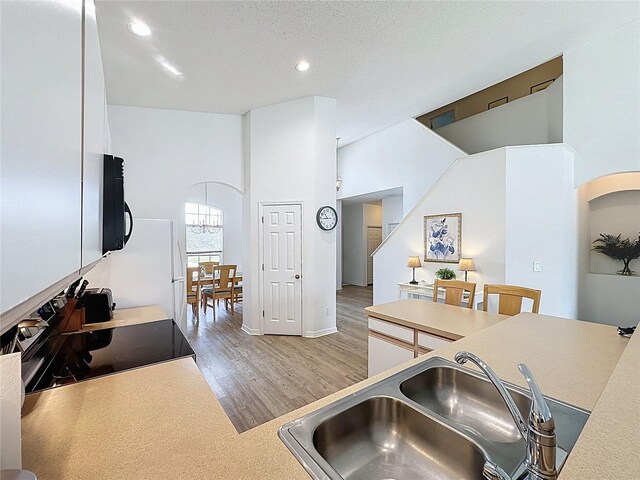 344 Bloomingdale Dr, Davenport, FL 33897 - kitchen with electric range, white cabinets, light wood finished floors, light countertops, and recessed lighting