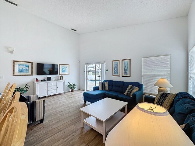 344 Bloomingdale Dr, Davenport, FL 33897 - living area with wood finished floors, a high ceiling, and a textured ceiling