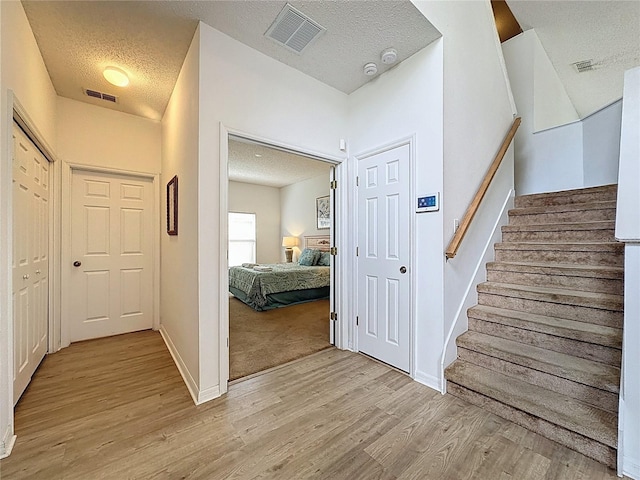 344 Bloomingdale Dr, Davenport, FL 33897 - hallway with a textured ceiling, light wood-style flooring, and stairs