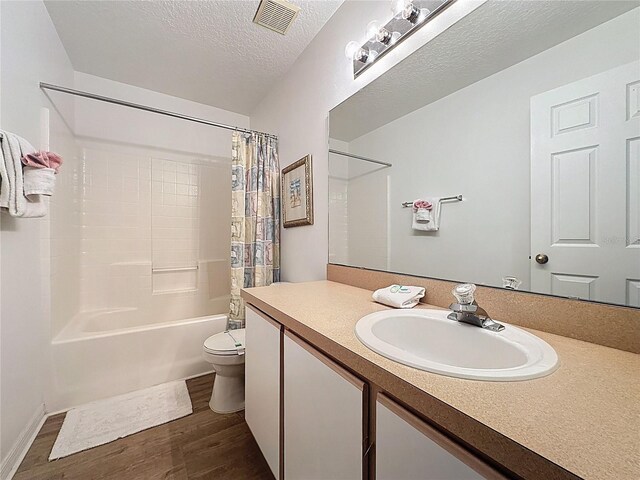 344 Bloomingdale Dr, Davenport, FL 33897 - full bathroom featuring wood finished floors, vanity, shower / tub combo with curtain, and a textured ceiling
