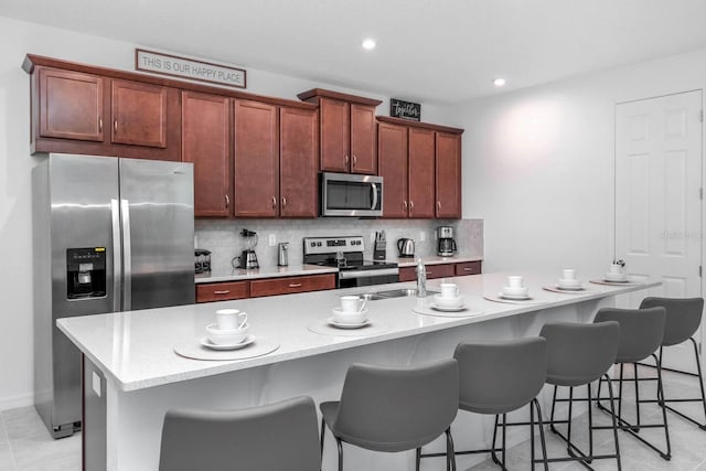 8937 Amelia Downs Trl, Kissimmee, FL 34747 - kitchen with stainless steel appliances, a center island with sink, backsplash, a breakfast bar, and recessed lighting