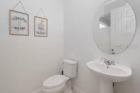 8937 Amelia Downs Trl, Kissimmee, FL 34747 - half bath featuring toilet and baseboards
