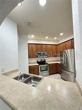 3351 Whitestone Cir Unit 204, Kissimmee, FL 34741 - kitchen featuring stainless steel appliances, light countertops, a peninsula, recessed lighting, and brown cabinetry