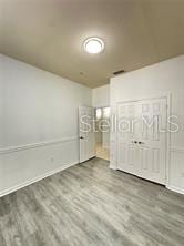 3351 Whitestone Cir Unit 204, Kissimmee, FL 34741 - unfurnished bedroom with wood finished floors and baseboards