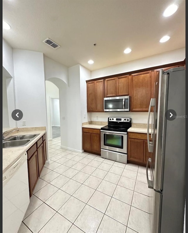 3351 Whitestone Cir Unit 204, Kissimmee, FL 34741 - kitchen with stainless steel appliances, arched walkways, light countertops, recessed lighting, and light tile patterned floors