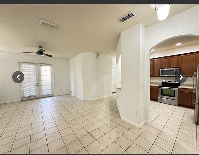 3351 Whitestone Cir Unit 204, Kissimmee, FL 34741 - kitchen with stainless steel appliances, light tile patterned flooring, arched walkways, open floor plan, and light countertops