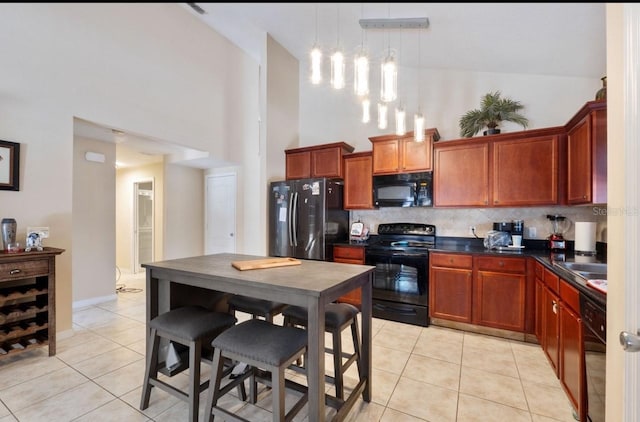 877 Scrub Jay Way, Davenport, FL 33896 - kitchen featuring black appliances, dark countertops, a towering ceiling, light tile patterned floors, and backsplash