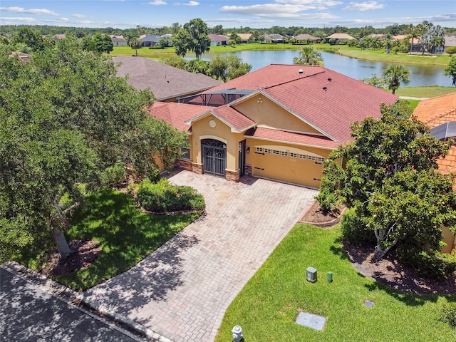 217 Sorrento Rd, Poinciana, FL 34759 - mediterranean / spanish-style home with stucco siding, a garage, decorative driveway, a water view, and a front yard