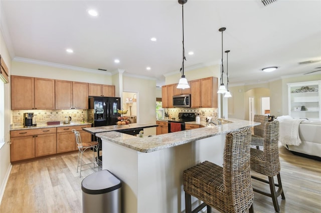 217 Sorrento Rd, Poinciana, FL 34759 - kitchen featuring black appliances, arched walkways, a breakfast bar area, crown molding, and tasteful backsplash