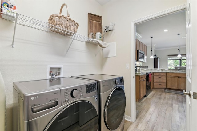 217 Sorrento Rd, Poinciana, FL 34759 - washroom featuring washer and dryer, light wood finished floors, and crown molding