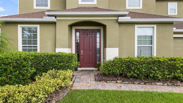 12353 Hammock Hill Dr, Clermont, FL 34711 - doorway to property featuring roof with shingles and stucco siding
