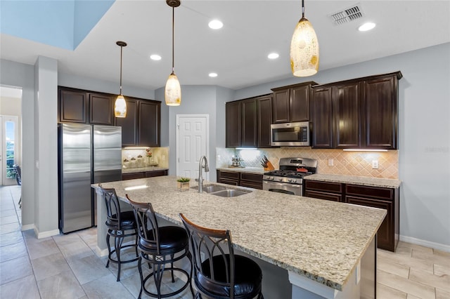 12353 Hammock Hill Dr, Clermont, FL 34711 - kitchen with stainless steel appliances, dark brown cabinets, a breakfast bar, decorative backsplash, and decorative light fixtures