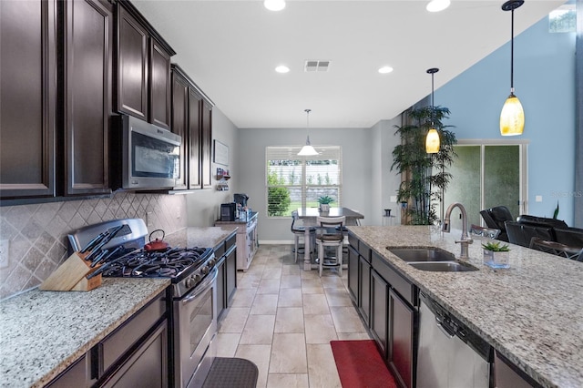12353 Hammock Hill Dr, Clermont, FL 34711 - kitchen featuring appliances with stainless steel finishes, dark brown cabinetry, backsplash, light stone counters, and recessed lighting