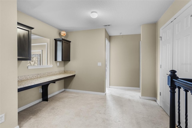 12353 Hammock Hill Dr, Clermont, FL 34711 - kitchen with built in study area, light colored carpet, light countertops, and dark brown cabinetry