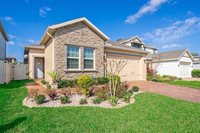 1456 Sourwood Dr, Ocoee, FL 34761 - view of front of property with stone siding, an attached garage, driveway, and stucco siding