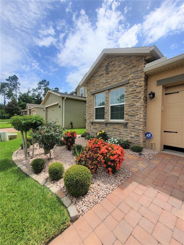1456 Sourwood Dr, Ocoee, FL 34761 - view of front of home with stone siding, an attached garage, and stucco siding