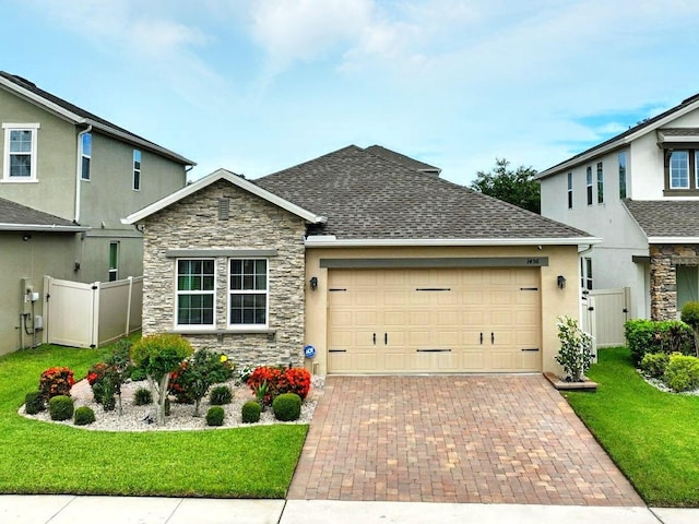 1456 Sourwood Dr, Ocoee, FL 34761 - view of front of home featuring stone siding, an attached garage, decorative driveway, stucco siding, and a gate