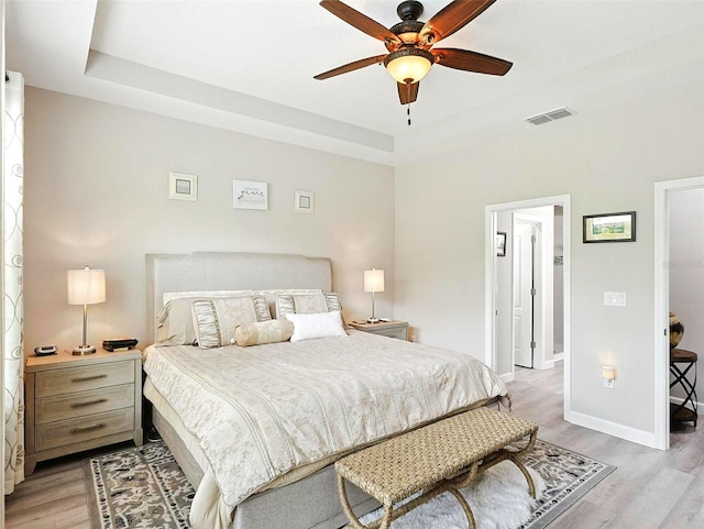 1456 Sourwood Dr, Ocoee, FL 34761 - bedroom featuring light wood finished floors, a raised ceiling, and a ceiling fan