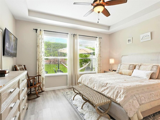 1456 Sourwood Dr, Ocoee, FL 34761 - bedroom with a raised ceiling, light wood-style flooring, and ceiling fan