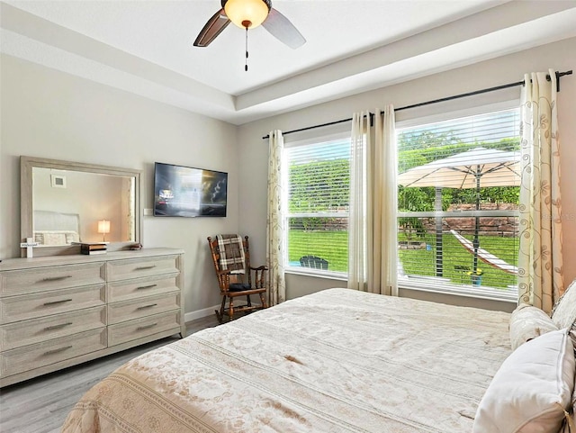 1456 Sourwood Dr, Ocoee, FL 34761 - bedroom featuring wood finished floors, a ceiling fan, and a tray ceiling