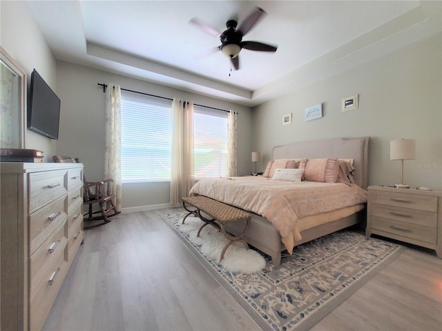 1456 Sourwood Dr, Ocoee, FL 34761 - bedroom featuring light wood finished floors, a raised ceiling, and a ceiling fan