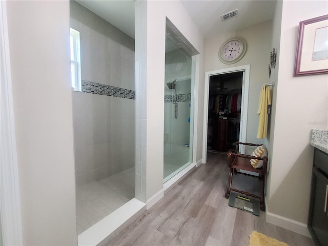 1456 Sourwood Dr, Ocoee, FL 34761 - bathroom with walk in shower, vanity, a spacious closet, and wood finished floors