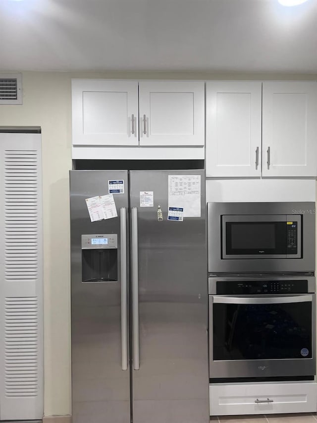 6831 SW 147th Ave Unit 3H, Miami, FL 33193 - kitchen with appliances with stainless steel finishes, white cabinets, and a heating unit