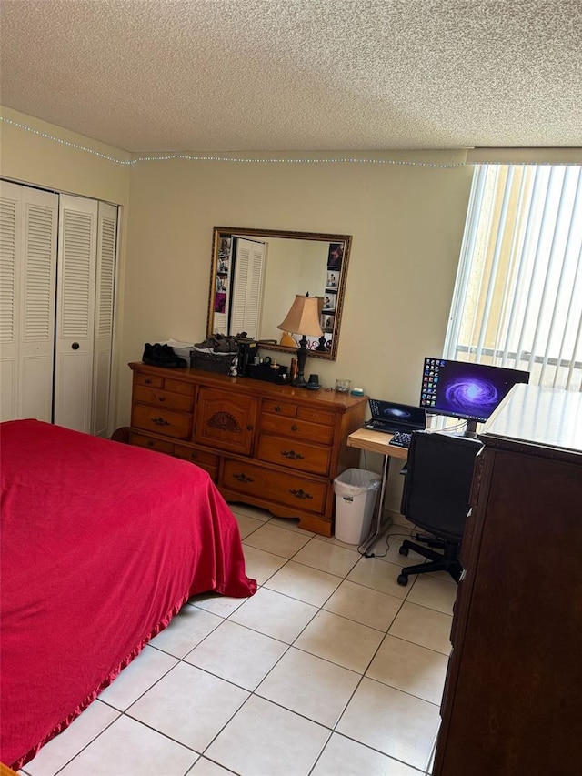6831 SW 147th Ave Unit 3H, Miami, FL 33193 - bedroom with a textured ceiling, light tile patterned floors, a closet, and a desk