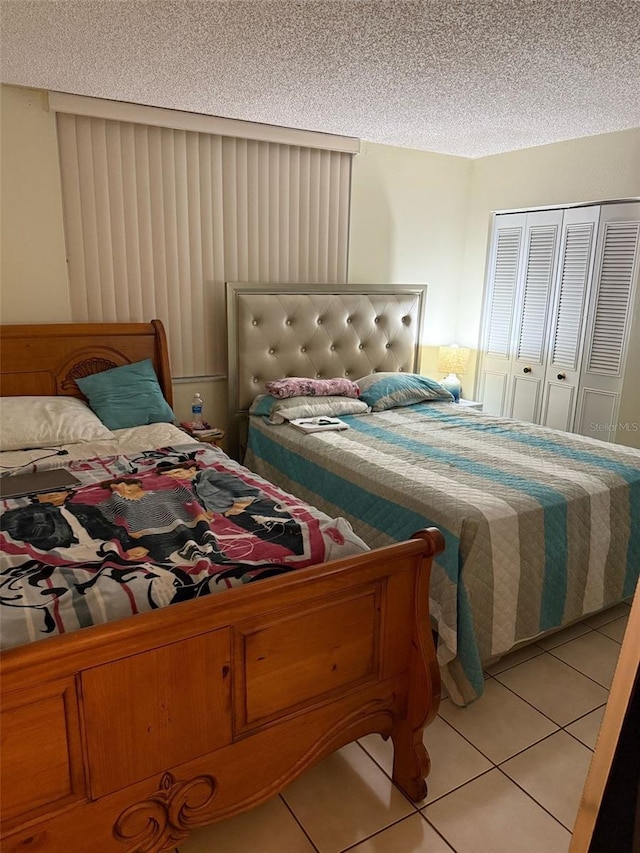 6831 SW 147th Ave Unit 3H, Miami, FL 33193 - bedroom with a textured ceiling, light tile patterned flooring, and a closet