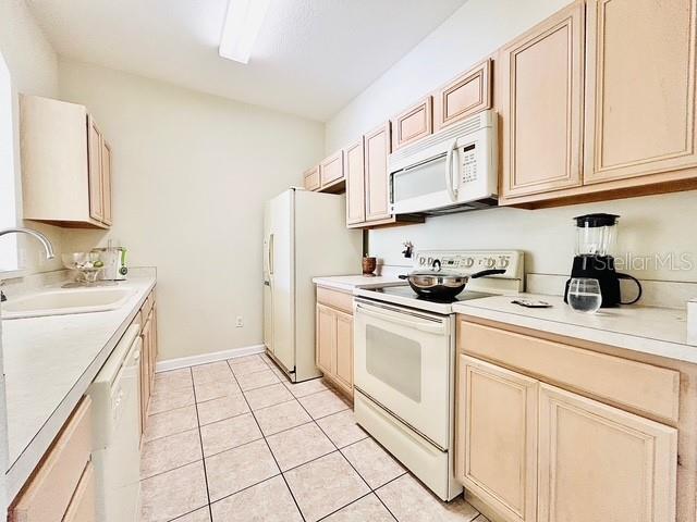 13500 Turtle Marsh Loop Unit 17, Orlando, FL 32837 - kitchen with white appliances, light tile patterned floors, and light countertops