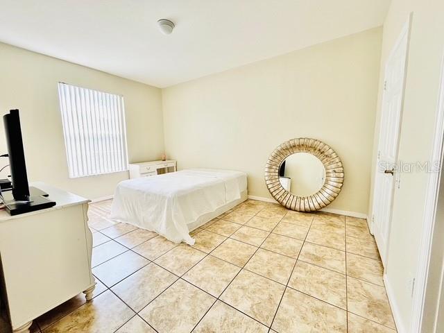 13500 Turtle Marsh Loop Unit 17, Orlando, FL 32837 - bedroom with light tile patterned floors and baseboards