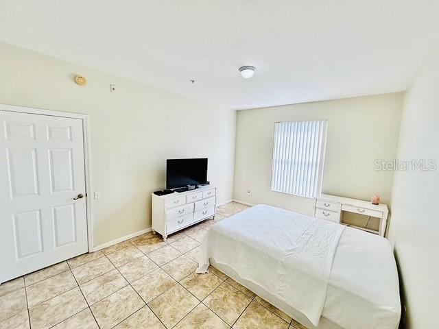 13500 Turtle Marsh Loop Unit 17, Orlando, FL 32837 - bedroom with light tile patterned floors and baseboards