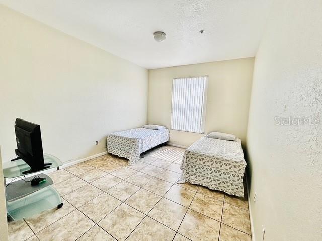 13500 Turtle Marsh Loop Unit 17, Orlando, FL 32837 - bedroom with light tile patterned flooring and baseboards