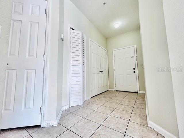 13500 Turtle Marsh Loop Unit 17, Orlando, FL 32837 - foyer with light tile patterned floors and baseboards