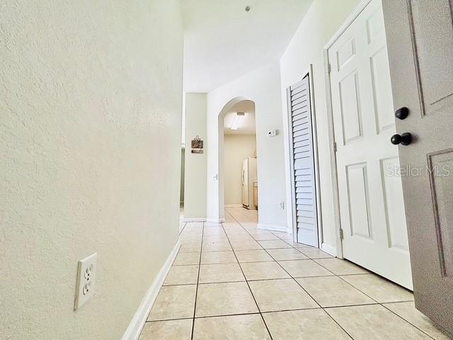 13500 Turtle Marsh Loop Unit 17, Orlando, FL 32837 - hallway with arched walkways and light tile patterned flooring