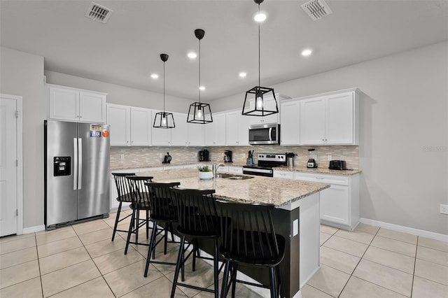 2131 Lelani Cir, Davenport, FL 33897 - kitchen featuring appliances with stainless steel finishes, backsplash, light tile patterned floors, an island with sink, and recessed lighting