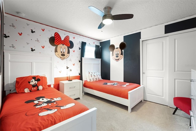 2131 Lelani Cir, Davenport, FL 33897 - bedroom featuring wallpapered walls, light carpet, a textured ceiling, a closet, and a wainscoted wall