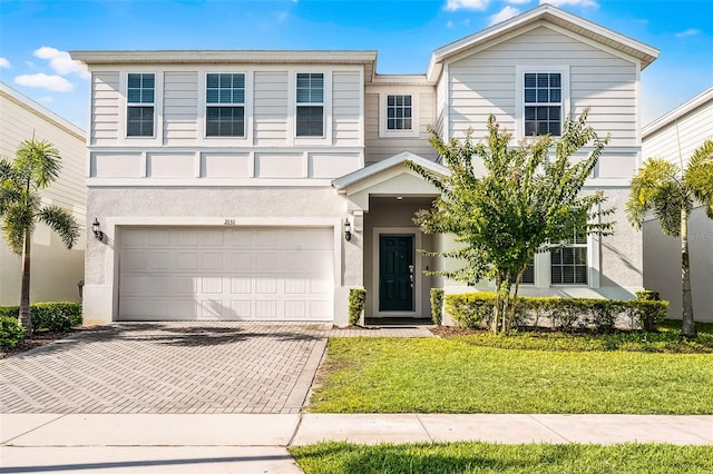 2131 Lelani Cir, Davenport, FL 33897 - view of front of home featuring decorative driveway, a garage, a front yard, and stucco siding
