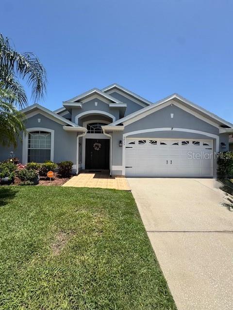 5435 Bryce Canyon Dr, Kissimmee, FL 34758 - ranch-style house featuring a garage, driveway, stucco siding, and a front lawn