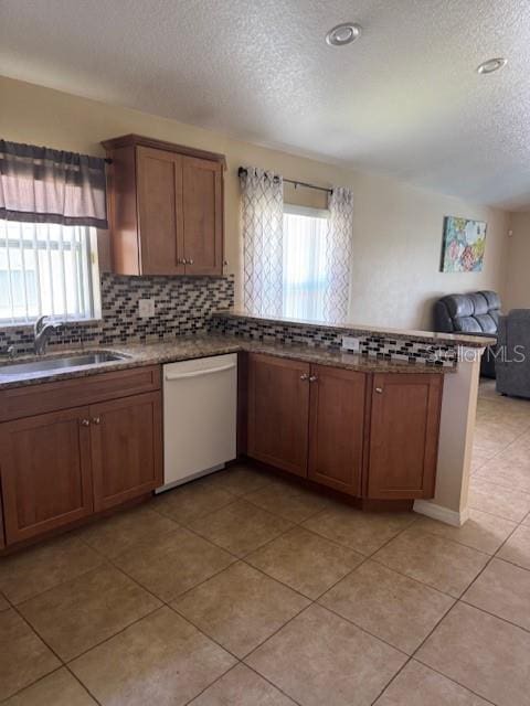 5435 Bryce Canyon Dr, Kissimmee, FL 34758 - kitchen with white dishwasher, a textured ceiling, a peninsula, open floor plan, and decorative backsplash